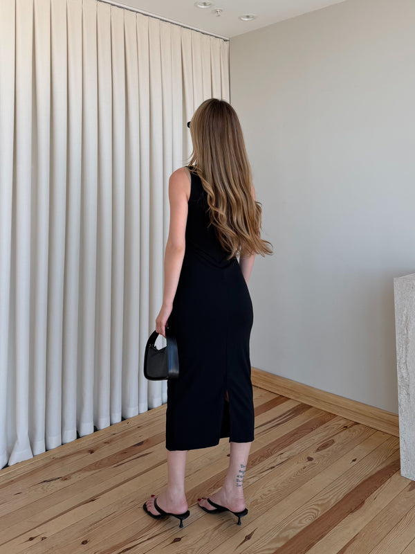 Siyah drapeli polyester midi elbisenin paça akışı yandan dinamik çekim