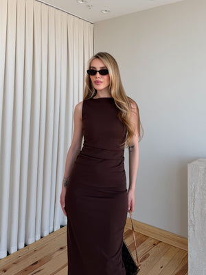 Kahverengi drapeli polyester midi elbisenin kumaş akışı ve paçası yandan çekim