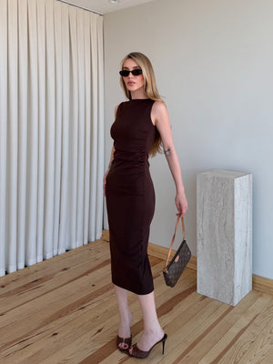 Kahverengi drapeli polyester midi elbisenin paça silueti ve kumaş akışı tam yan profil