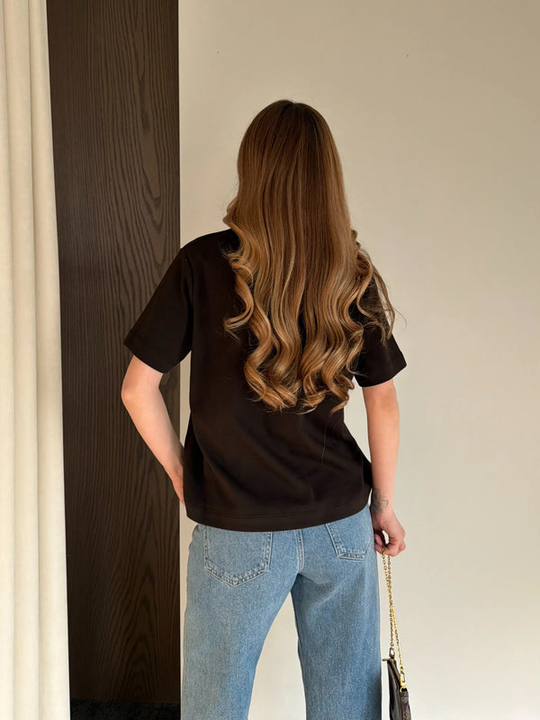 Kahverengi kısa kollu pamuklu tişört, ham denim pantolon kombini, ön-yan açıdan tam boy çekim